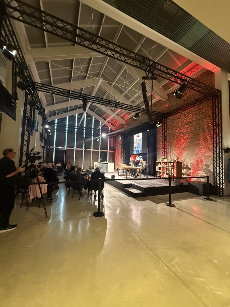 Una sala di Cook Fest 2026 con palco, pubblico e monitor durante gli incontri